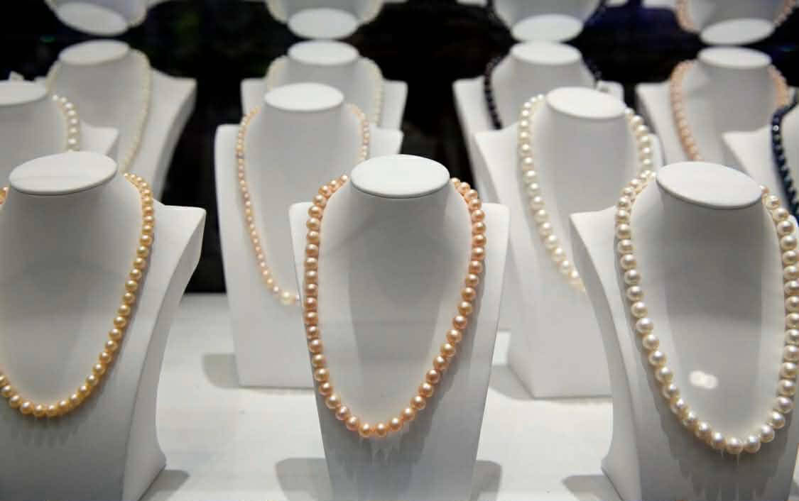 Kolekce perlových náhrdelníků vystavených v klenotnictví na ostrově