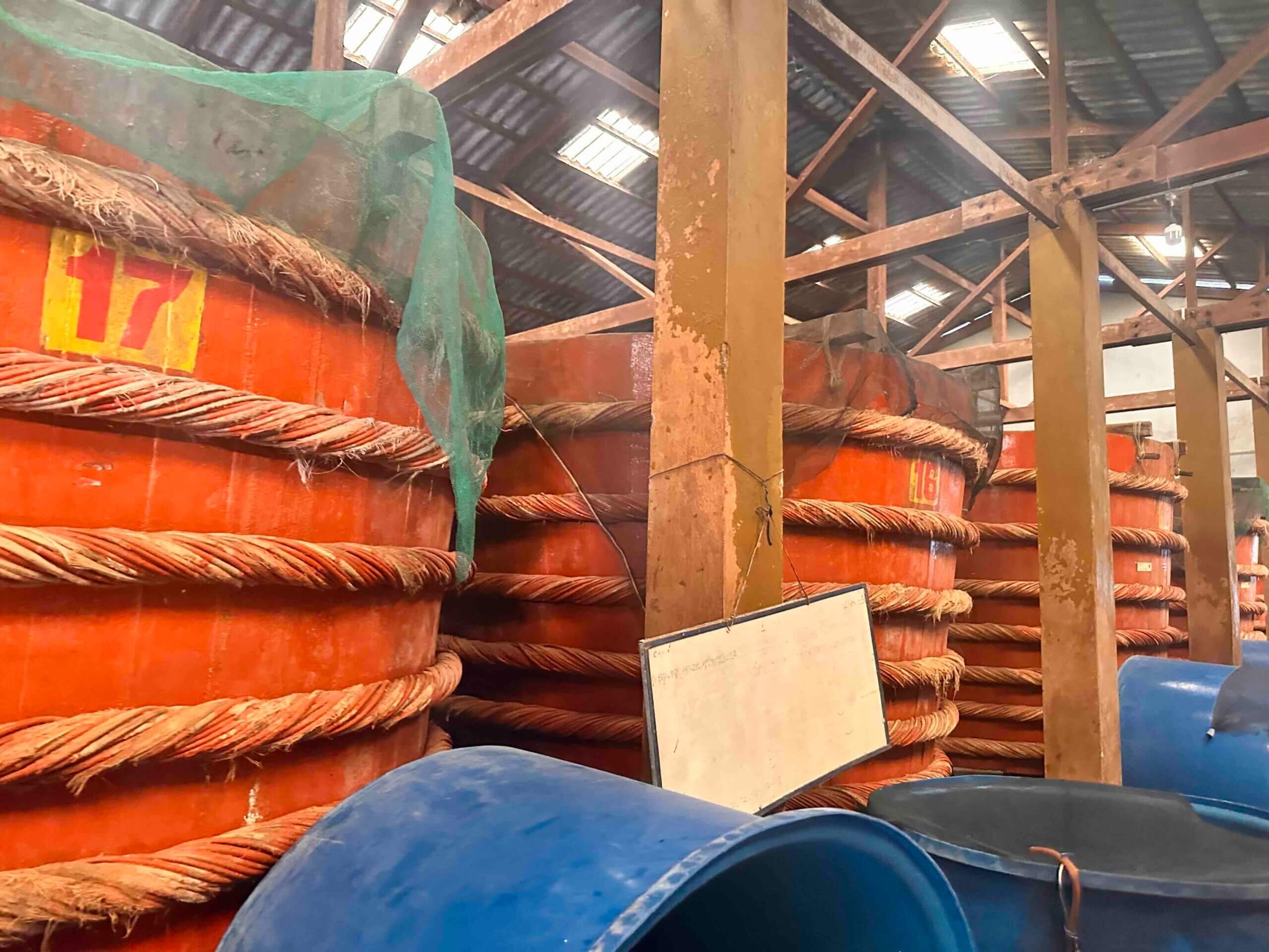 Detailní pohled na očíslované dřevěné sudy stažené silnými provazy