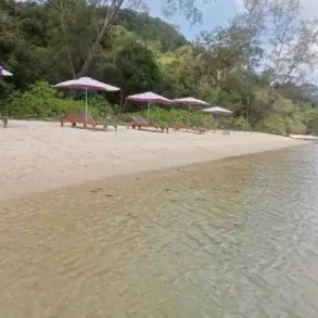Relaxační zóna na písečné pláži s lehátky a slunečníky u klidného, mělkého moře na Phu Quoc.