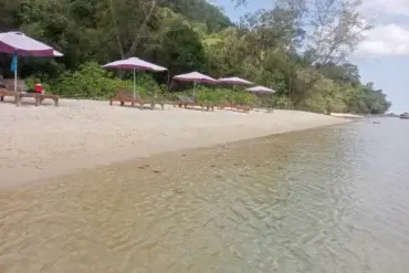 Relaxační zóna na písečné pláži s lehátky a slunečníky u klidného, mělkého moře na Phu Quoc.