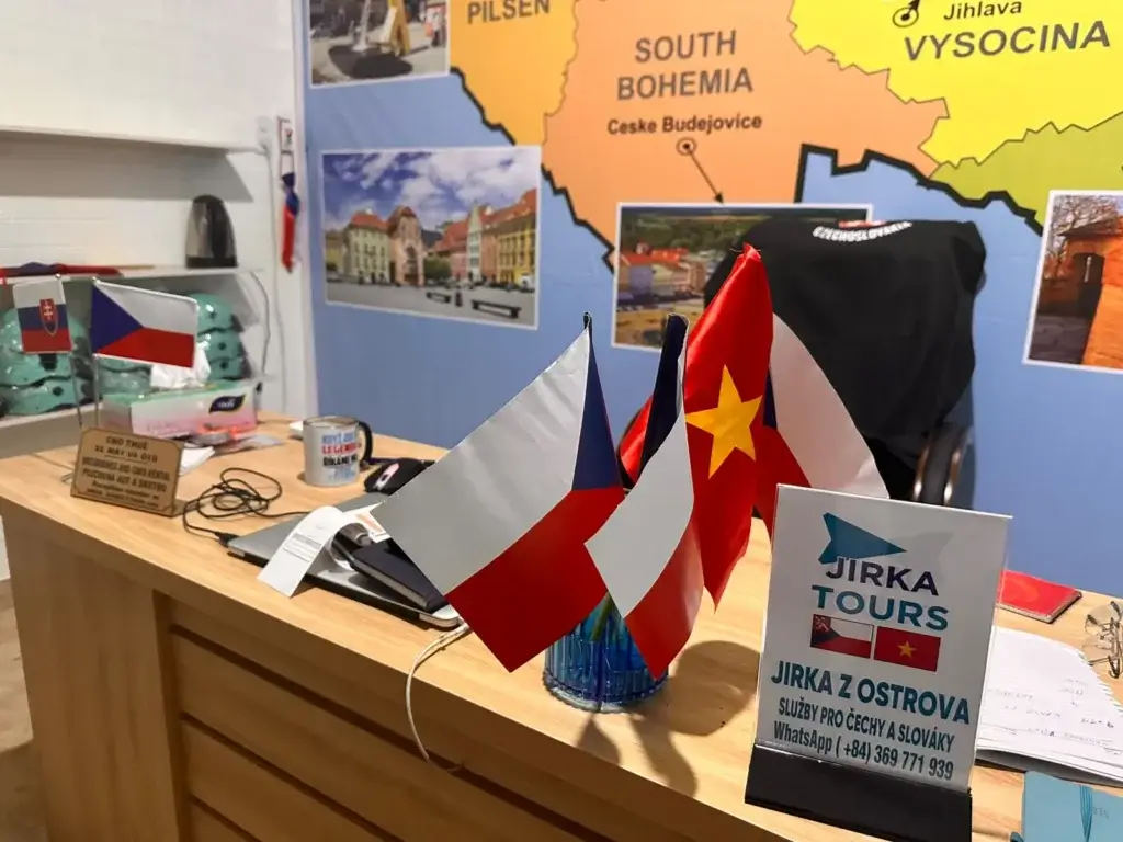 Česká a vietnamská vlajka na stole Jirka Tours před mapou Česka